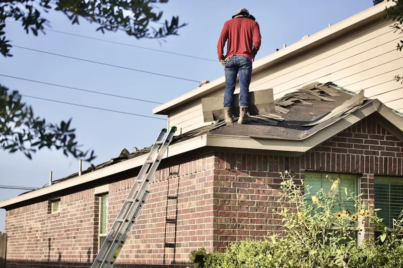 Professional roofer working on a residential roof in Jamaica Hills - Pond